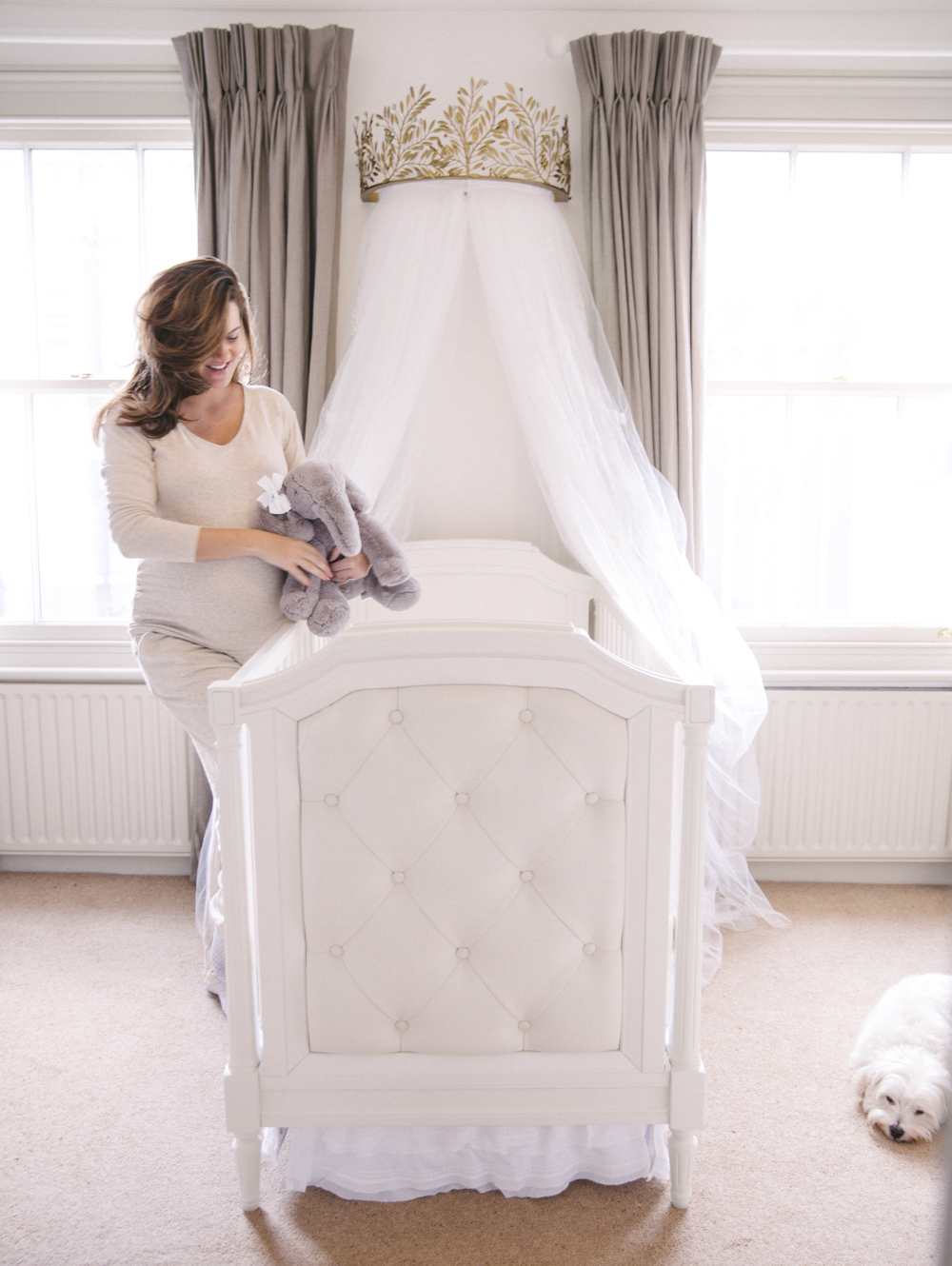 Upholstered crib in a cream and white nursery